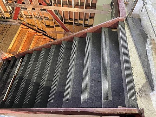 a concrete stairway on one level with a wood stairway on the next level down