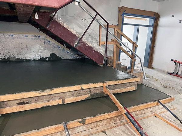 a stair under construction with fresh poured concrete below it