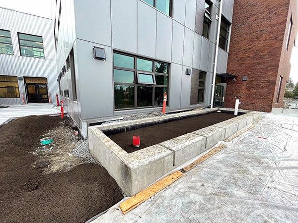 a brick and metal clas building with a concrete planter