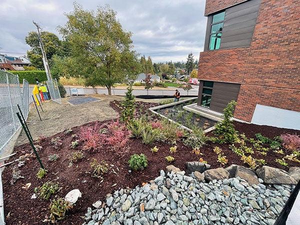 plants and rocks in front of a brick building